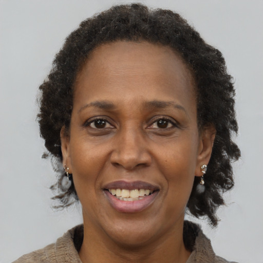 Joyful black adult female with long  brown hair and brown eyes