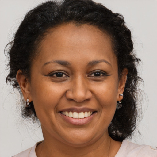 Joyful black adult female with medium  brown hair and brown eyes
