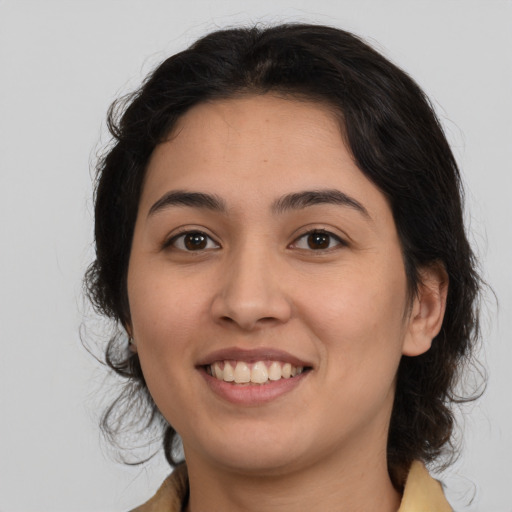 Joyful latino young-adult female with medium  brown hair and brown eyes