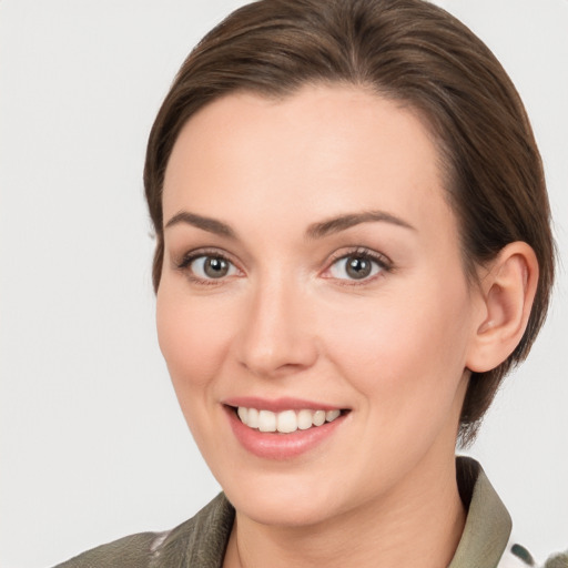 Joyful white young-adult female with medium  brown hair and grey eyes