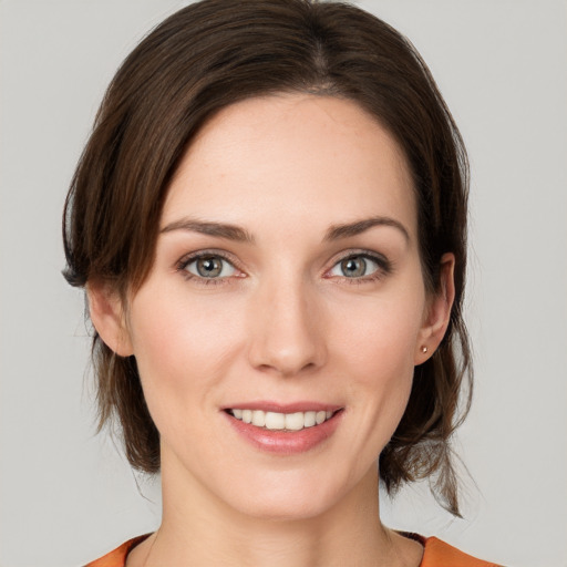 Joyful white young-adult female with medium  brown hair and grey eyes