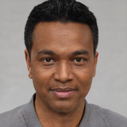 Joyful black young-adult male with short  black hair and brown eyes