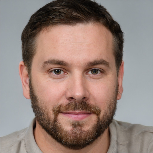 Joyful white young-adult male with short  brown hair and grey eyes