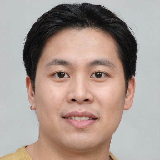 Joyful asian young-adult male with short  brown hair and brown eyes