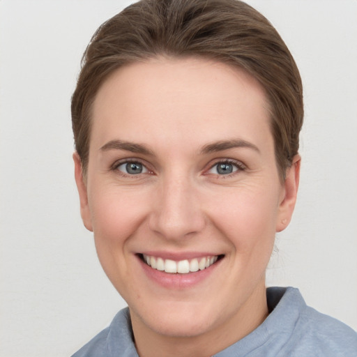 Joyful white young-adult female with short  brown hair and grey eyes