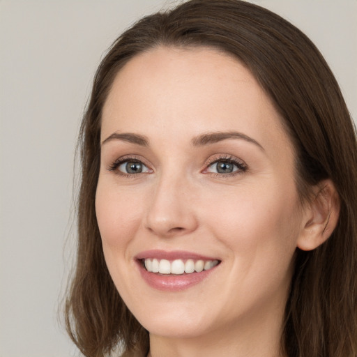 Joyful white young-adult female with long  brown hair and grey eyes