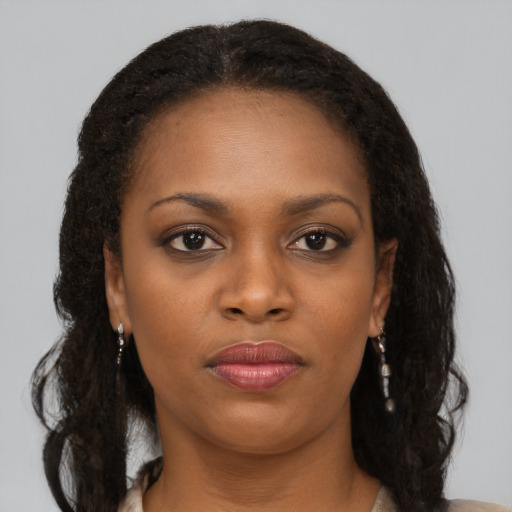 Joyful black young-adult female with long  brown hair and brown eyes