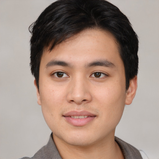 Joyful asian young-adult male with short  black hair and brown eyes