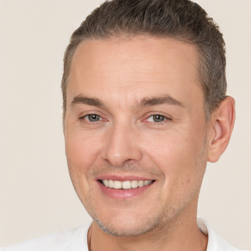 Joyful white adult male with short  brown hair and brown eyes