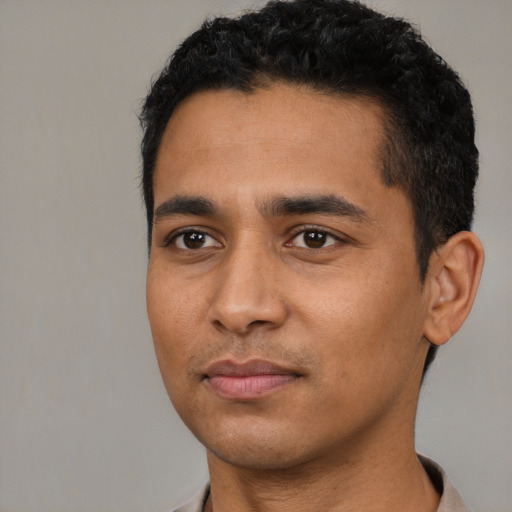 Joyful latino young-adult male with short  black hair and brown eyes