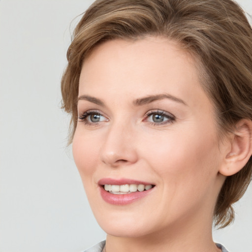 Joyful white young-adult female with medium  brown hair and grey eyes