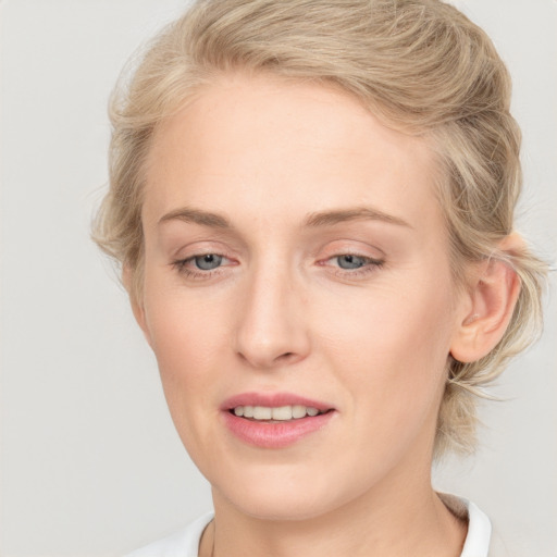 Joyful white young-adult female with medium  brown hair and blue eyes