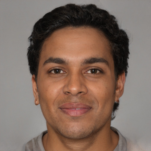 Joyful latino young-adult male with short  brown hair and brown eyes