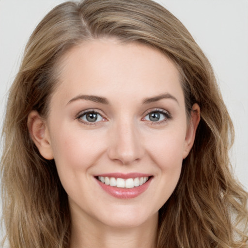 Joyful white young-adult female with long  brown hair and blue eyes