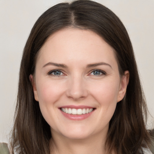 Joyful white young-adult female with long  brown hair and grey eyes