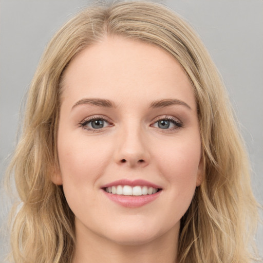 Joyful white young-adult female with long  brown hair and blue eyes