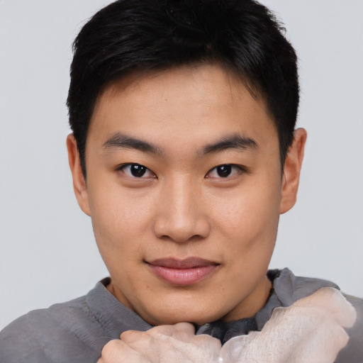 Joyful asian young-adult male with short  brown hair and brown eyes
