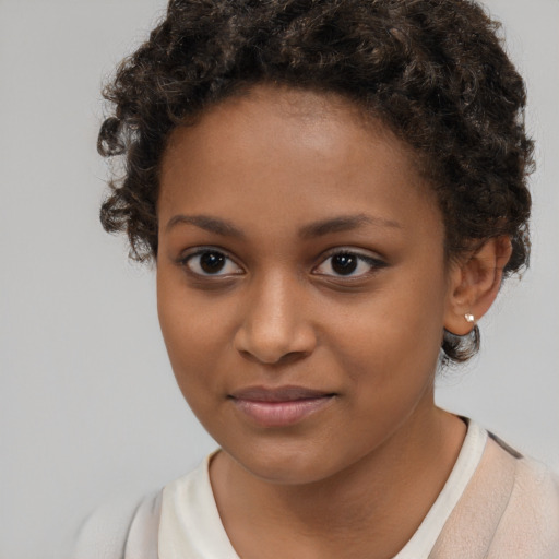 Joyful black child female with short  brown hair and brown eyes