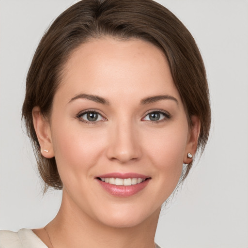 Joyful white young-adult female with medium  brown hair and grey eyes