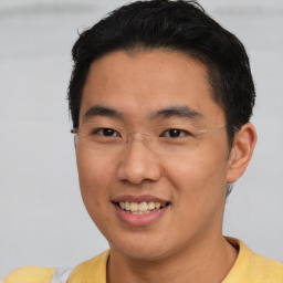 Joyful asian young-adult male with short  brown hair and brown eyes