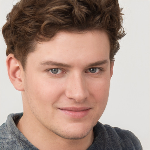 Joyful white young-adult male with short  brown hair and blue eyes