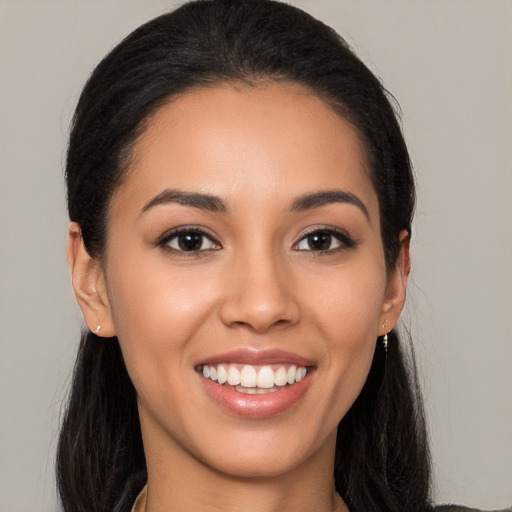 Joyful latino young-adult female with long  brown hair and brown eyes