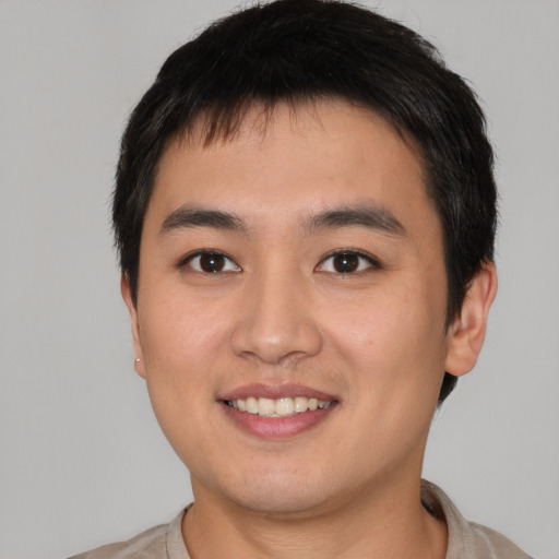 Joyful asian young-adult male with short  brown hair and brown eyes