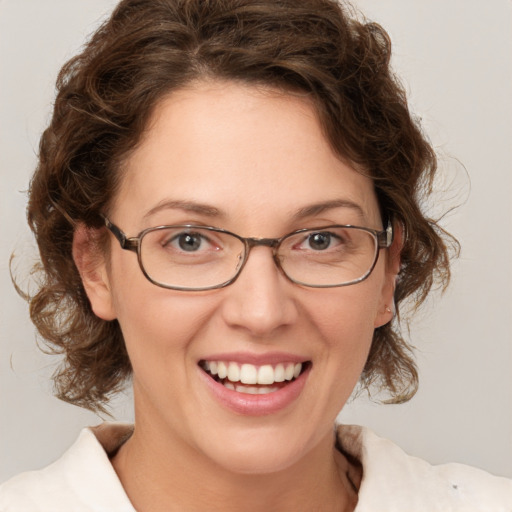 Joyful white adult female with medium  brown hair and green eyes