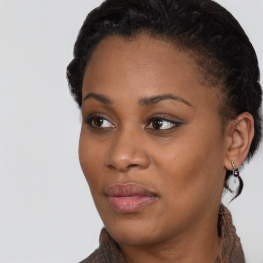 Joyful black young-adult female with short  black hair and brown eyes