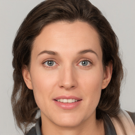 Joyful white young-adult female with medium  brown hair and grey eyes