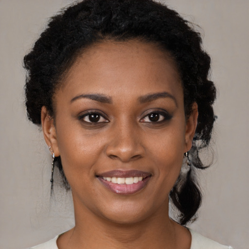 Joyful black young-adult female with medium  brown hair and brown eyes