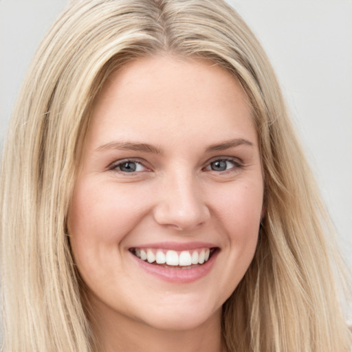 Joyful white young-adult female with long  brown hair and blue eyes