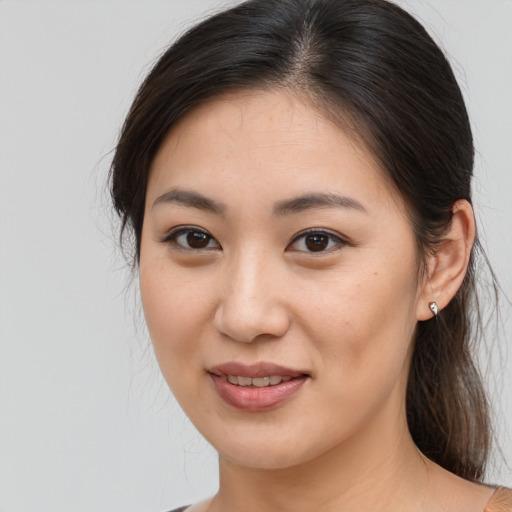 Joyful asian young-adult female with medium  brown hair and brown eyes