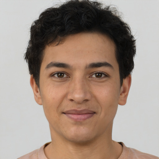 Joyful latino young-adult male with short  brown hair and brown eyes