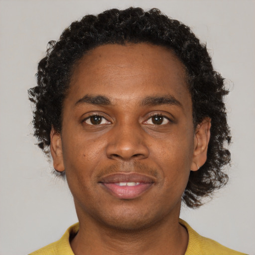 Joyful black young-adult male with short  brown hair and brown eyes