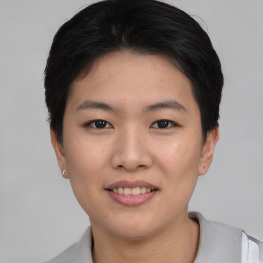 Joyful asian young-adult female with short  black hair and brown eyes