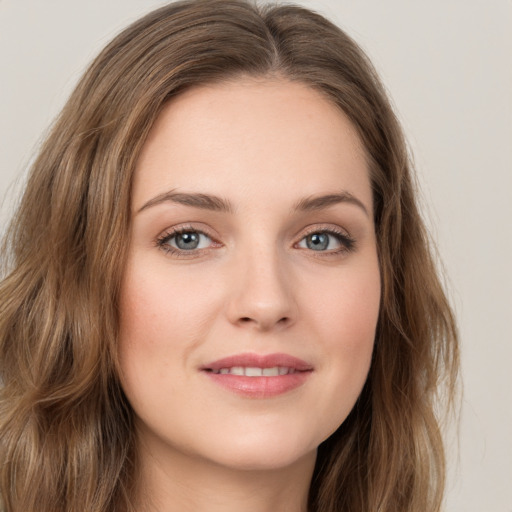 Joyful white young-adult female with long  brown hair and green eyes