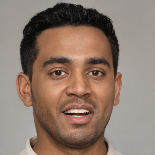 Joyful latino young-adult male with short  black hair and brown eyes