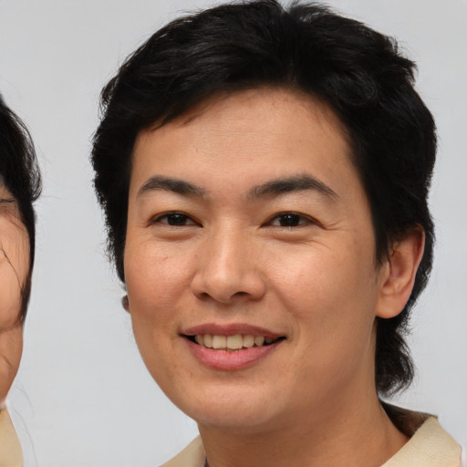 Joyful asian young-adult female with medium  brown hair and brown eyes