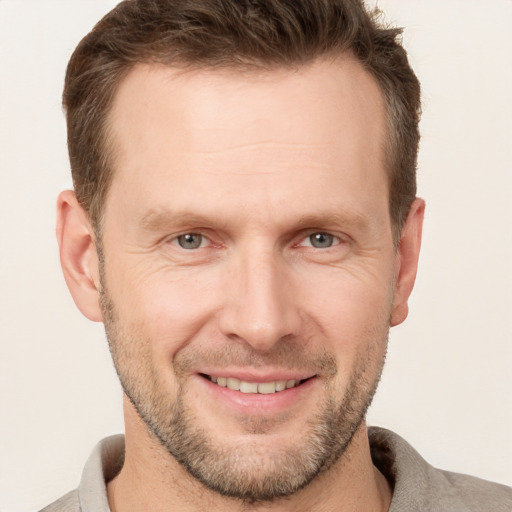 Joyful white adult male with short  brown hair and brown eyes