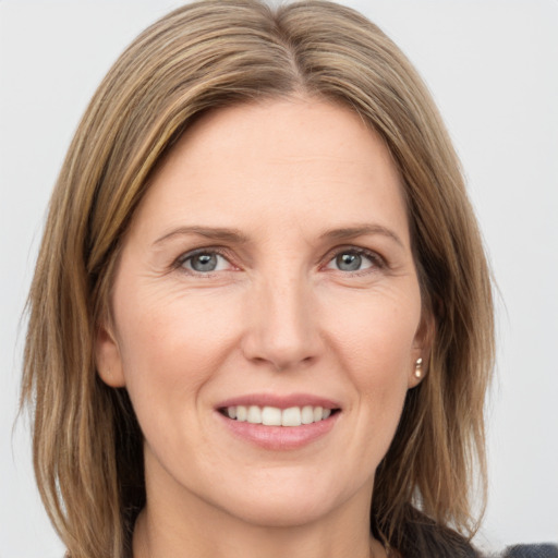 Joyful white adult female with medium  brown hair and grey eyes