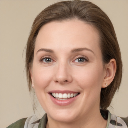 Joyful white young-adult female with medium  brown hair and green eyes