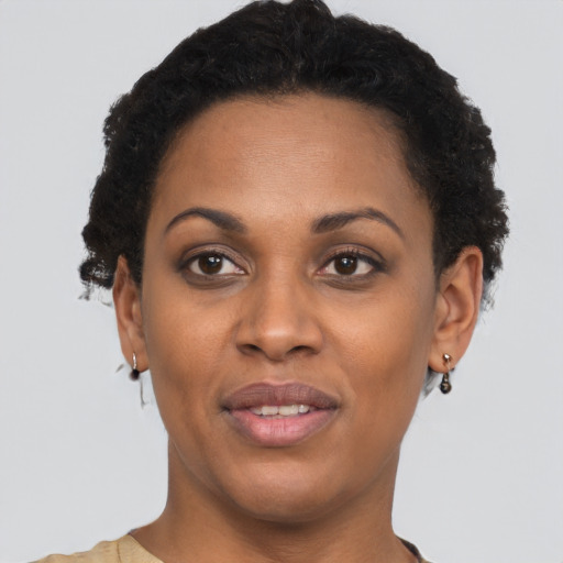 Joyful black young-adult female with short  brown hair and brown eyes