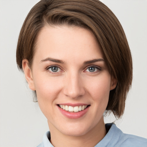 Joyful white young-adult female with medium  brown hair and grey eyes