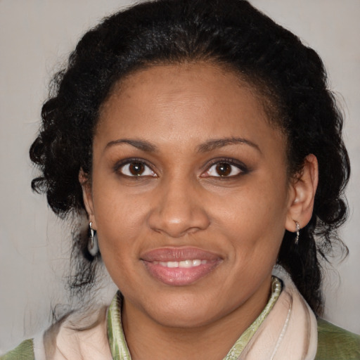 Joyful black adult female with medium  brown hair and brown eyes