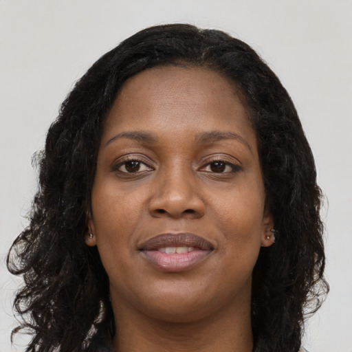 Joyful black young-adult female with long  black hair and brown eyes