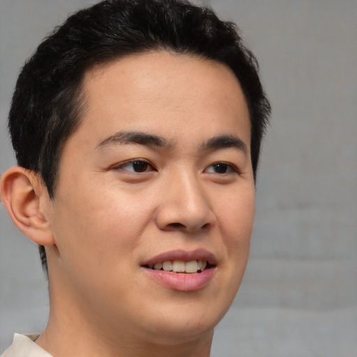 Joyful asian young-adult male with short  brown hair and brown eyes