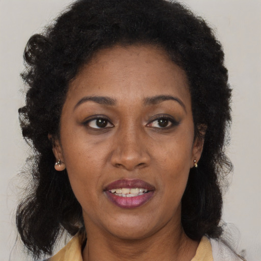Joyful black adult female with medium  brown hair and brown eyes