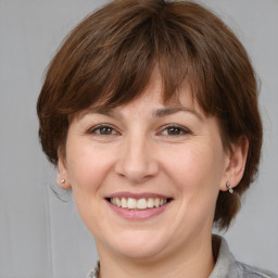 Joyful white adult female with medium  brown hair and grey eyes