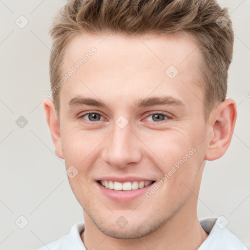 Joyful white young-adult male with short  brown hair and grey eyes